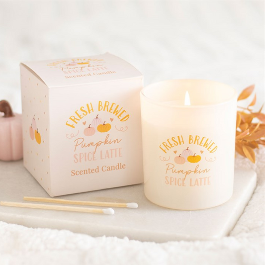 Scented candle with packaging labeled 'Fresh Brewed Pumpkin Spice Latte' on a white surface.