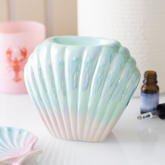 Shell-shaped ceramic vase on a white surface with a blurred background