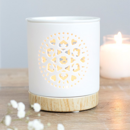 White ceramic candle holder with wooden base on a wooden surface