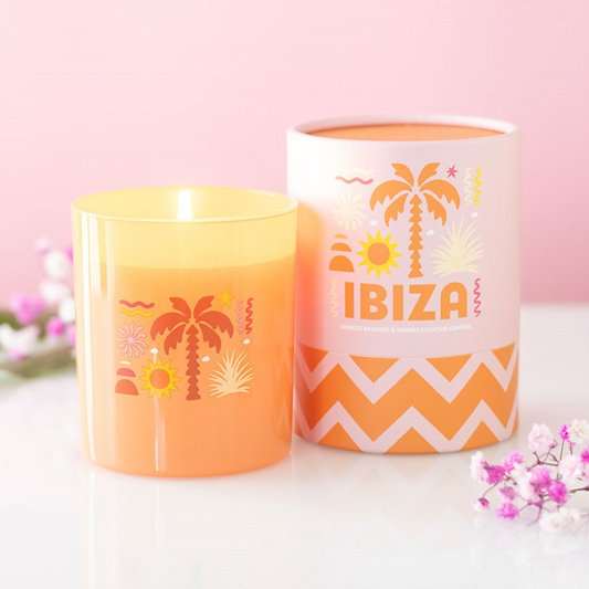 Two candles with palm tree designs and 'Ibiza' text on a pink background