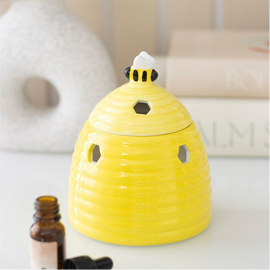 Yellow bee-shaped diffuser on a white surface with a blurred background