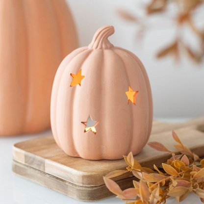 Decorative pumpkin with star cutouts on a wooden surface with a blurred background