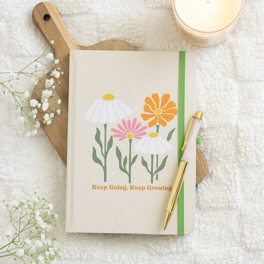 Notebook with floral design and pen on a textured surface